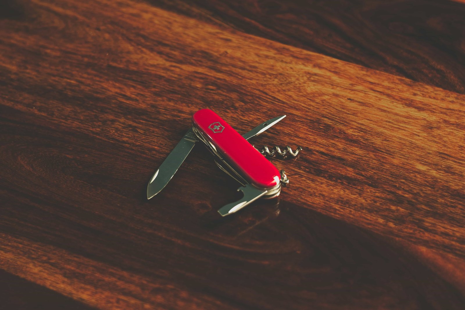 Red Swiss Army knife on a wooden table